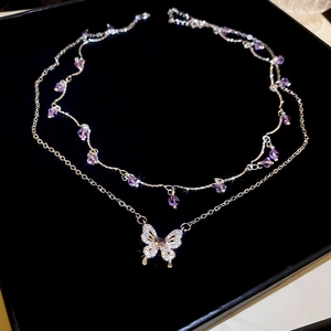 Detail view of silver double-layered necklace with purple beads and butterfly pendant