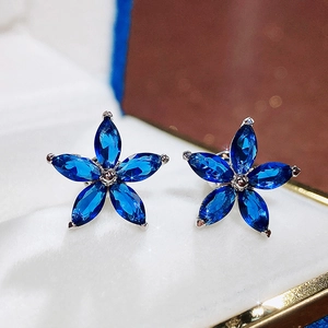Detailed macro view of royal blue flower stud earrings with marquise cut stones
