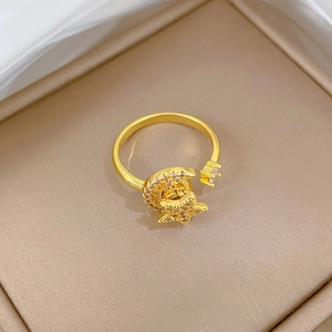 Close-up of rotatable gold-plated star and moon ring with pavé zircons on jewelry box