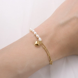Detailed view of S925 silver bracelet with freshwater pearls and a golden heart charm