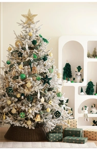 Close-up of decorated Christmas tree with green velvet ornaments and warm fairy lights