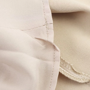 Gros plan sur le tissu en satin champagne montrant les coutures et la texture lisse