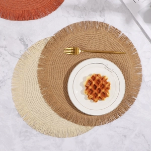 Tovagliette rotonde intrecciate con nappe in beige e marrone su tavolo di marmo