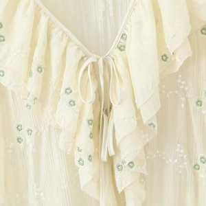 Abito alla moda in chiffon beige con scollo a V, ricamo floreale e dettagli a balze