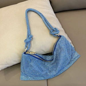 Macro detail of blue rhinestone shoulder bag with crystal knotted strap and gold zipper