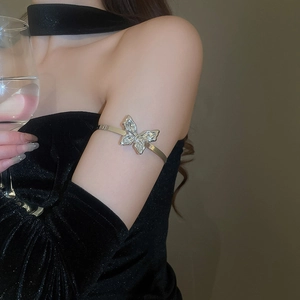 Detail of sparkling butterfly arm cuff with silver plating and zircon inlay on woman's arm