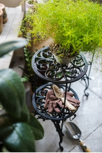 Détail du support de plante à deux niveaux en fonte avec des motifs floraux classiques