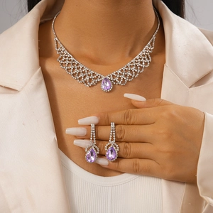Detail of purple teardrop crystal necklace and earring set with silver diamond paving