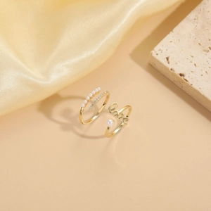 Detailed macro shot of 14K gold plated ring featuring love letter design and white pearls