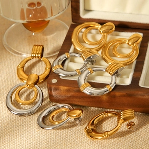Detail shot of multi-layer gold and silver mixed metal hoop earrings on wooden storage