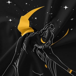Detailed close-up of bohemian sun and moon tapestry with gold crescent on black fabric