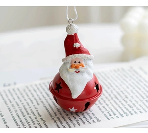 Detailed view of Santa Claus resin ornament with red hollowed metal star bell and cotton rope