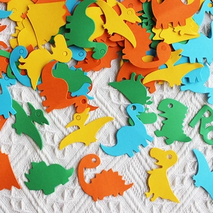 Colorful dinosaur confetti shapes including T-Rex and Stegosaurus for party decoration