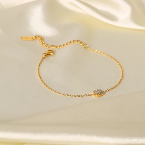 Detail eines 18K vergoldeten Edelstahlarmbandes mit einem quadratischen Zirkonia Anhänger