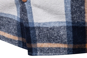 Detailed close-up of dark blue plaid flannel shirt showing hem stitching and fabric texture