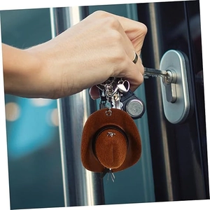Close-up of a mini brown felt cowboy hat keychain being used to open a door lock