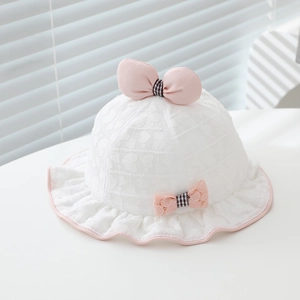 Détail d'un chapeau de soleil pour bébé avec dentelle en cœur et nœuds roses à carreaux