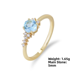 Detail view of gold ring featuring 5mm light blue topaz and 1.65g weight specification