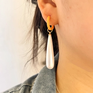 Fashionable stainless steel hoop earrings with orange resin and white teardrop pearls