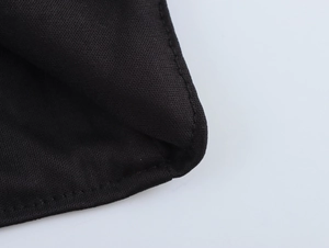 Gros plan des coutures de qualité et de la texture pailletée noire de la robe de soirée