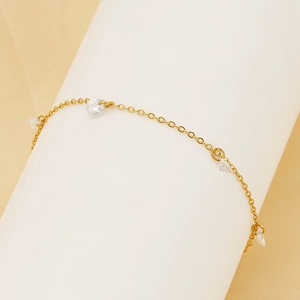 Detailed macro view of a gold O-chain bracelet with clear round zircon charms