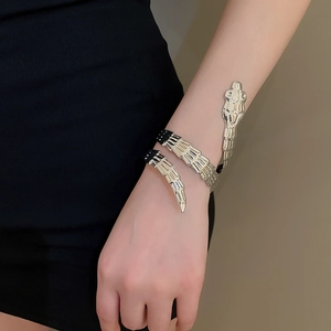Detailed close-up of golden snake-shaped bracelet with intricate scale textures and coils