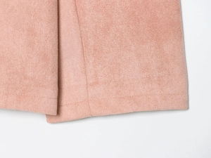 Detailed macro view of pink faux suede fabric texture with premium stitching quality