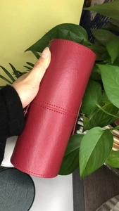 Close-up of deep red leather makeup brush holder with stitch detail and snap closure