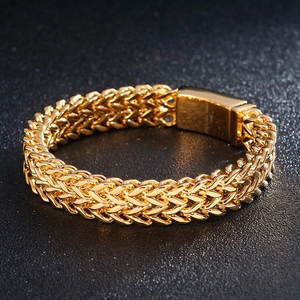 Detailed macro view of the gold double-row wheat chain texture and polished clasp