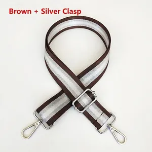 Detail of adjustable nylon bag strap in coffee and silver stripes with metal hooks
