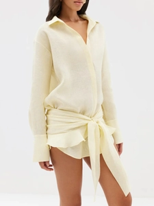 Detail of pale yellow linen shirt dress with wrap-around waist tie and large decorative bow