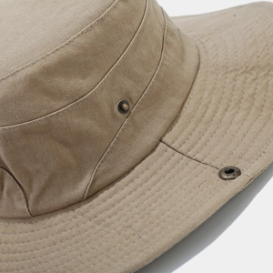 Close-up of brown camouflage fishing hat featuring fishbone canvas and metal eyelet