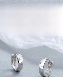 Detailed close-up showing the S925 silver stamp and zircon star design on the earrings