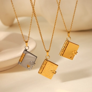 Macro detail of envelope-shaped locket necklaces in gold and silver with heart cutouts