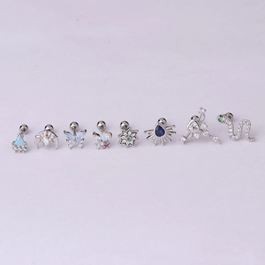 Flat lay of assorted stainless steel cartilage studs with colorful zircon and opal stones