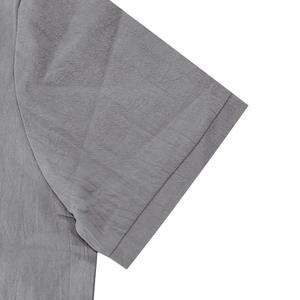 Detailed close-up of grey linen polo shirt sleeve showing fabric texture and stitching