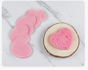 Macro shot of pink heart-shaped wood pulp cellulose sponges on a wooden stand