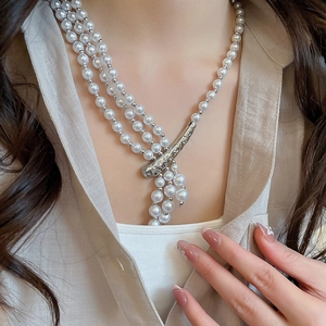 Detail of multi-layer pearl necklace with irregular silver branch-shaped metal clasp