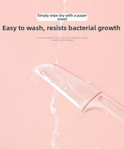 Macro shot of pink foldable eyebrow razor under water showing easy cleaning and safety guard