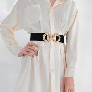Close-up of elastic black waist belt featuring a luxury interlocking gold metal buckle