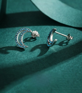 Detailed close-up of S925 sterling silver crescent moon earrings with turquoise stones