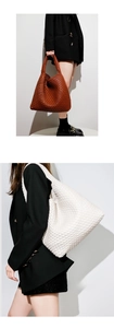 Detail view of large woven tote bags in brown and white leather style finishes
