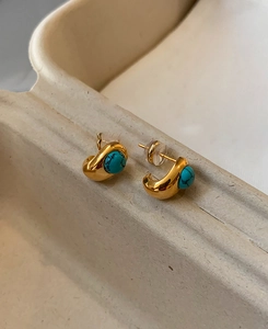 Detailed macro view of 18k gold plated stud earrings with green turquoise round beads