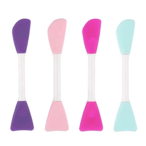 Set of four double-ended silicone facial mask brushes in purple, pink, rose, and mint blue