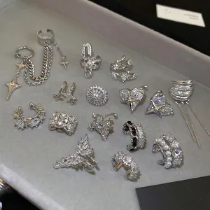 Silver zircon ear cuff collection featuring stars, wings, and hearts on a velvet tray