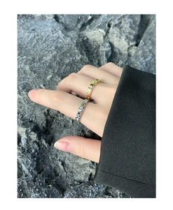 Close-up of gold and silver S925 rings with colored stones and irregular textures