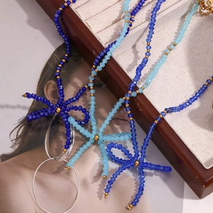 Detail of handcrafted blue faceted crystal beaded necklace with golden bead accents