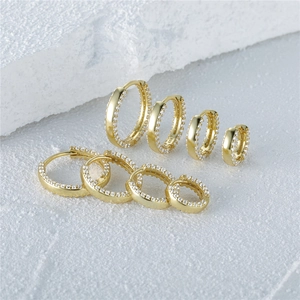 Macro detail of S925 sterling silver stamp on golden double row cubic zirconia hoop earrings