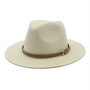 Detail of light beige woven Fedora hat featuring a brown leather band and gold buckle