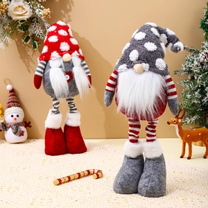 Detailed view of two handmade Christmas gnomes in red and grey on warm festive background